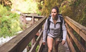 female-hiker-walking-across-bridge